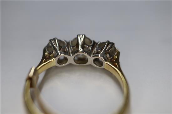 A yellow metal and three stone diamond ring, size H.